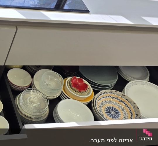 מגירת כלים מסודרת עם צלחות וכוסות